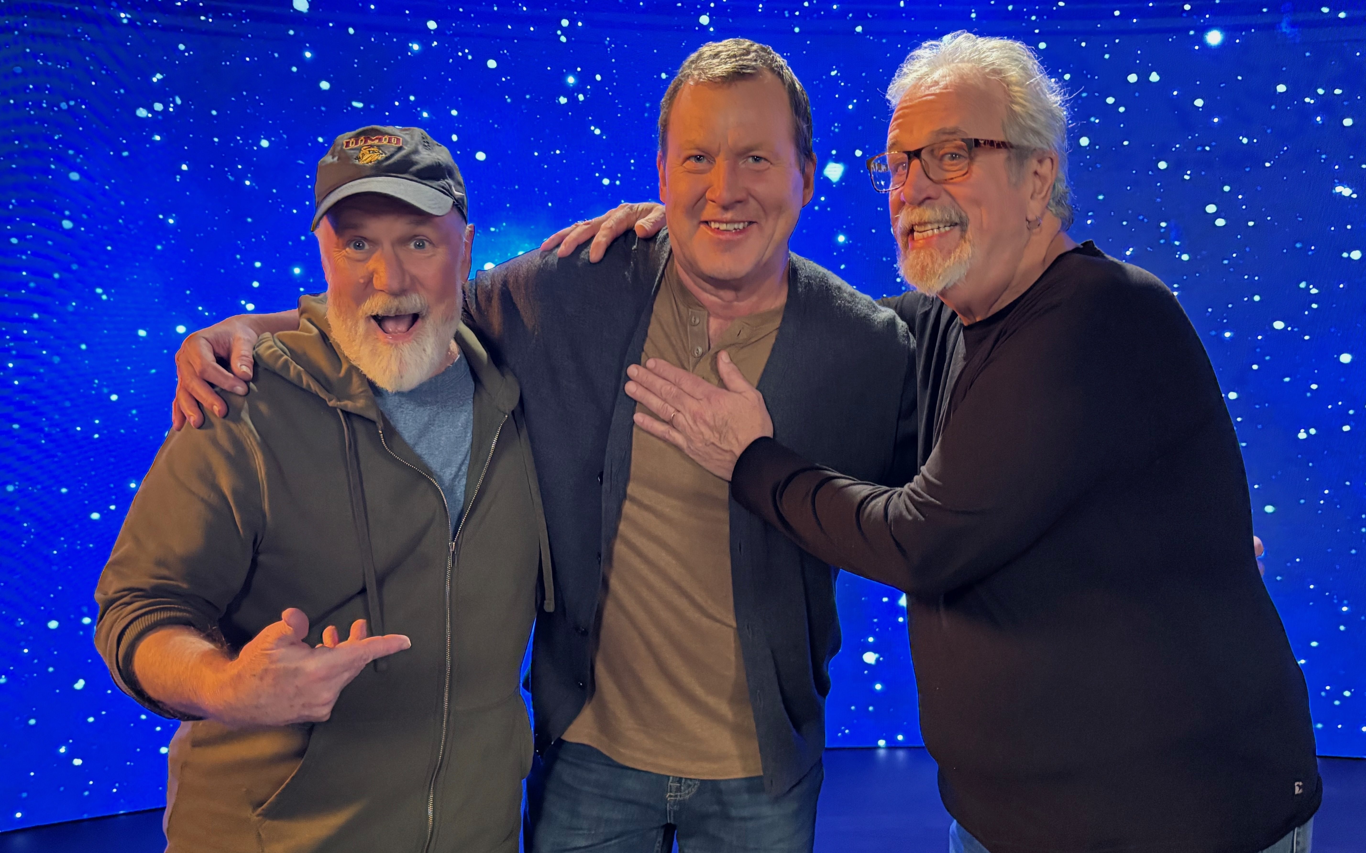 Звёзды Театра научной мистерии 3000 на фоне экрана с фильмом